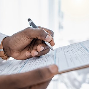 a man filling out paperwork on a clipboard