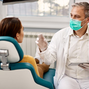 Dentist talking to patient in treatment room